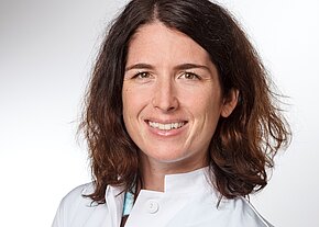 PD Dr. med. habil. Corinna Lang-Schwarz Porträt einer lächelnden Frau in weißem Kittel vor hellem Hintergrund. Mittellange, braune, leicht wellige Haare; freundlicher Blick. Wirkt wie medizinisches Fachpersonal.